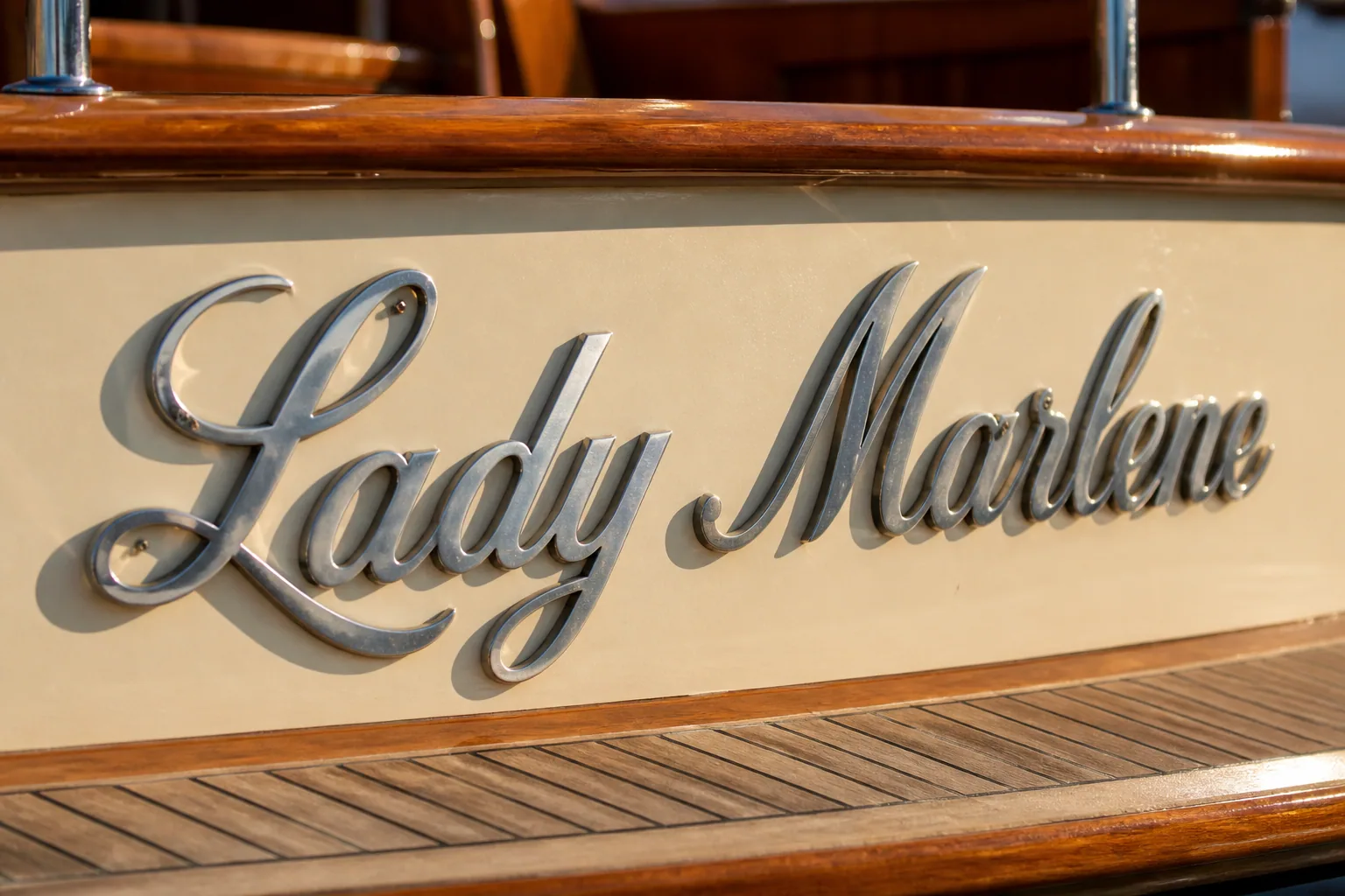 Classic script stainless steel yacht name letters on a heritage yacht stern conveying elegant personality and soft prestige.