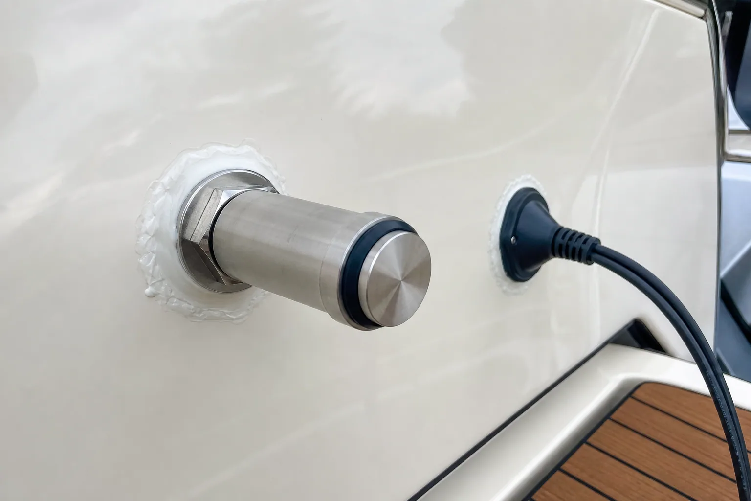 Stud-mount penetration with marine sealant and sealed cable entry on yacht transom.
